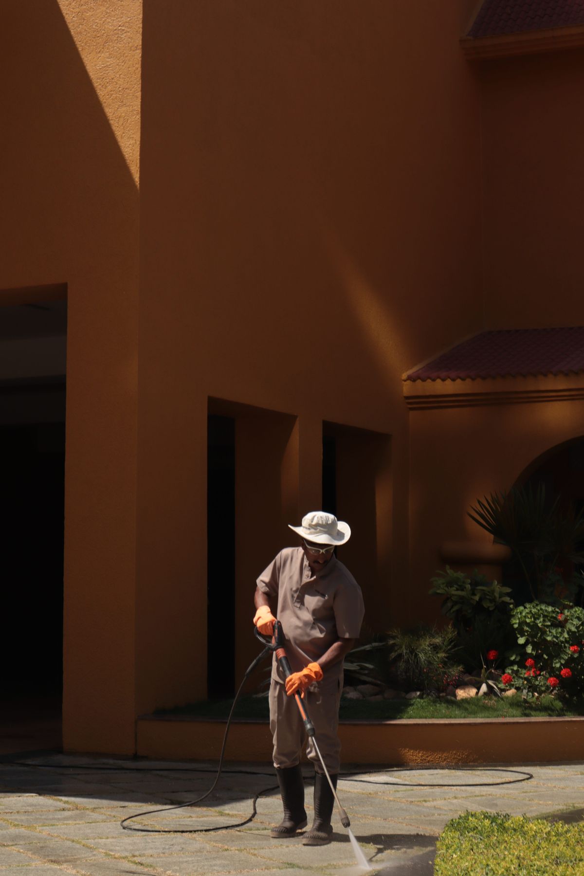 Worker using controlled pressure to clean a durable outdoor surface